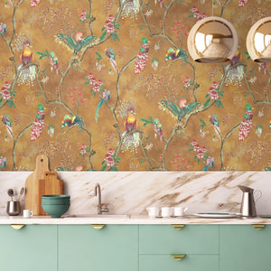 Birds in Paradise wallpaper by Brand McKenzie in gold, tropical birds on blossoming branches behind a console table