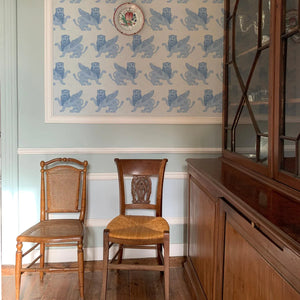 Winged Lion wallpaper by Annika Reed in blue, winged lions behind a console table