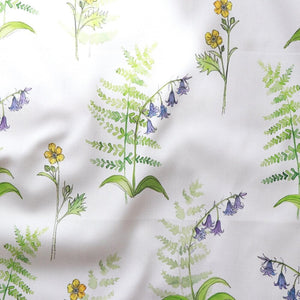 Buttercup and Bluebells fabric by Seed Home Designs in blue and yellow, draped, showing buttercups and bluebells