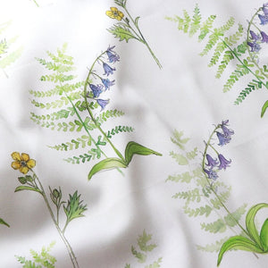 Buttercup and Bluebells fabric by Seed Home Designs in blue and yellow, in soft folds showing buttercups and bluebells