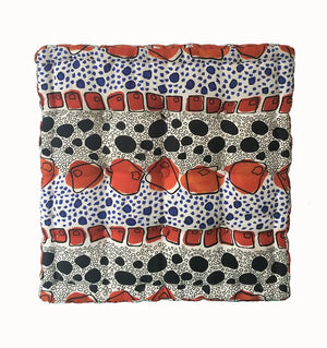 Cellular linen by Bethie Tricks in orange and black, bold cell shapes upholstered on a fringed footstool