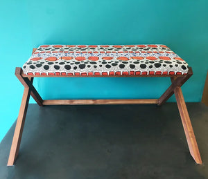 Cellular linen by Bethie Tricks in orange and black, bold cell shapes covering a footstool