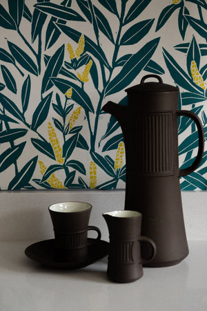 Climbing Vine wallpaper by Annika Reed in teal and yellow, climbing vines above a sideboard