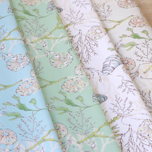 Coastal Cove fabric by Seed Home Designs in white, pattern sample of line-drawn shells and seaweed