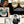 Connecting Frames wallpaper by Brand McKenzie in black and white, close-up of a gallery wall of framed portraits