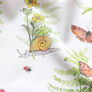 Cornish Woodland fabric by Seed Home Designs in green and orange, flat sample of woodland flowers and creatures