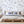 Cowes wallpaper by XV Interiors in blue, sailing boats and anchors behind a bed