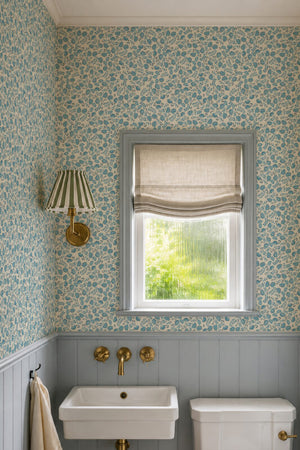 Annabelle wallpaper by Curate Space in teal, ditsy hand-painted florals in a powder room with a window and a basin