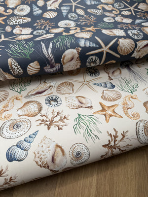 Charlotte wallpaper by Curate Space in light cream and midnight blue, hand-painted seashells and starfish, rolls in light cream and midnight blue shown together