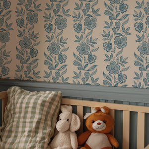 Dilys wallpaper by Curate Space in teal, a floral stripe in a nursery with a wooden bench and teddy bears