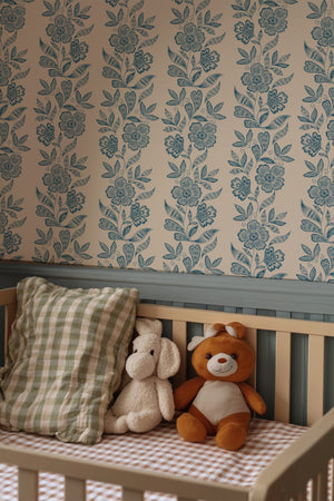 Dilys wallpaper by Curate Space in teal, a floral stripe in a nursery with a wooden bench and teddy bears