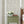 Elena wallpaper by Curate Space in light green, fine linear floral vines in a bedroom with a green bedside table