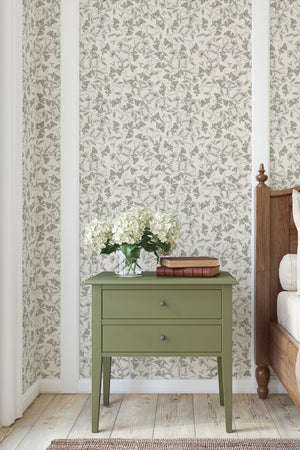 Elena wallpaper by Curate Space in light green, fine linear floral vines in a bedroom with a green bedside table