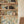 Eva wallpaper by Curate Space in off-white, a large-scale painterly floral in an alcove with open shelving