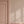 Mabel wallpaper by Curate Space in soft pink, small rosette motifs in a hallway with a pink door and panelling