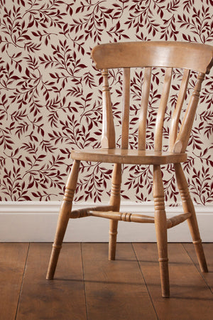 Marni wallpaper by Curate Space in rust orange, sweeping leafy vines in a room with a wooden chair
