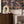 Mina wallpaper by Curate Space in midnight blue, dramatic layered florals and foliage in a living room with a wooden sideboard and a sculptural vase