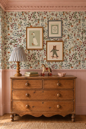 Nola wallpaper by Curate Space in off-white, wildflowers and tall stems in a bedroom with pink panelling and a wooden chest of drawers