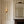 Olive Curate Space wallpaper in light cream, vertical stripes of botanical stems and wildflowers in a hall alcove with a fireplace and a gilt mirror