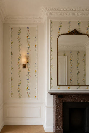 Olive Curate Space wallpaper in light cream, vertical stripes of botanical stems and wildflowers in a hall alcove with a fireplace and a gilt mirror