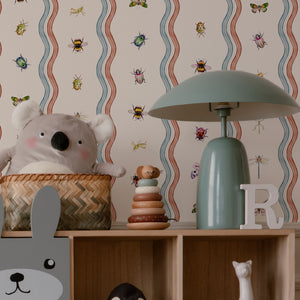Ren wallpaper by Curate Space in off-white, wavy stripes with bugs and butterflies in a nursery with shelves and soft toys