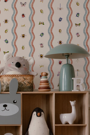 Ren wallpaper by Curate Space in off-white, wavy stripes with bugs and butterflies in a nursery with shelves and soft toys
