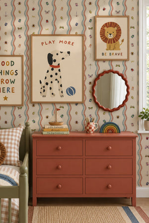 Ren wallpaper by Curate Space in off-white, wavy stripes with bugs and butterflies in a children's room with an orange chest and framed prints