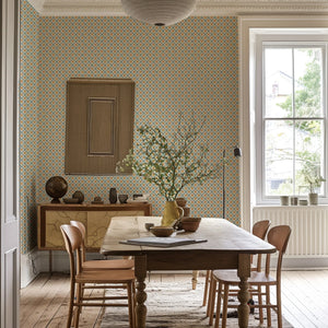 Solstice Sun wallpaper by Annika Reed in blue and orange, suns in a lattice in a dining area
