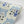 Pair of Dogs wallpaper by Annika Reed in blue, partly unrolled roll showing pairs of dogs and vases