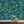 Eden wallpaper by Deus ex Gardenia in teal, lush leaves and fruit above a sideboard