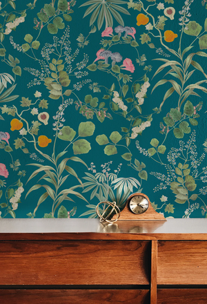 Eden wallpaper by Deus ex Gardenia in teal, lush leaves and fruit above a sideboard