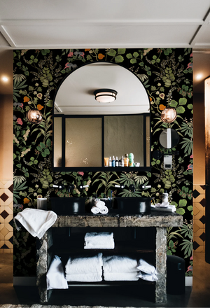 Eden wallpaper by Deus ex Gardenia in black, lush leaves and fruit in a bathroom