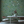 Eden wallpaper by Deus ex Gardenia in sage green, lush leaves and fruit on a living room wall