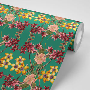 Hampi wallpaper by Tatie Lou in green, partly unrolled roll showing tropical flowers in a mirrored print