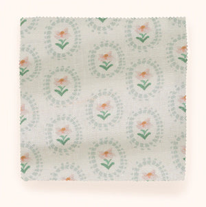 Folly linen by Parker and Jules in pale green, draped close-up of sunburst medallions
