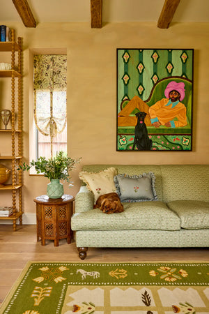 Folly linen by Parker and Jules in blue, sunburst medallions behind a sofa in a living room
