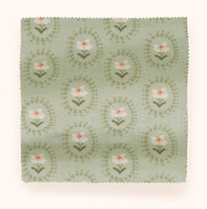 Folly linen by Parker and Jules in sage green, in soft folds showing sunburst medallions