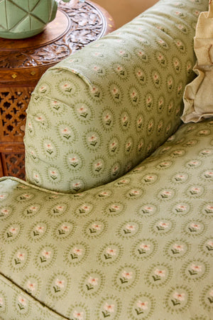 Folly linen by Parker and Jules in sage green, sunburst medallions covering an armchair