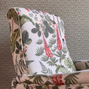 Folly wallpaper by Parker and Jules in beige, small sunburst medallions upholstered on an armchair