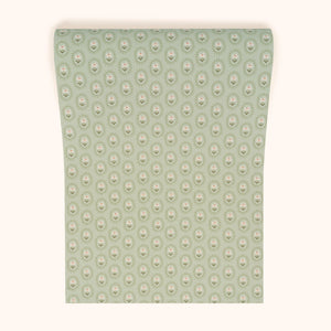 Folly wallpaper by Parker and Jules in sage green, sample roll showing small sunburst medallions