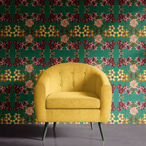 Hampi wallpaper by Tatie Lou in green, tropical flowers in a mirrored print behind a sofa in a living room