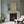 Harlequin Parade wallpaper by Annika Reed in blue, a small harlequin check around a fireplace
