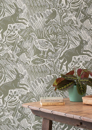 Harvest Hare wallpaper by St. Jude's in grey-green, hares among grasses above a sideboard