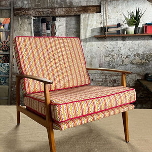 Heatwave linen by Bethie Tricks in orange and pink, wavy block-print stripes upholstered on an armchair