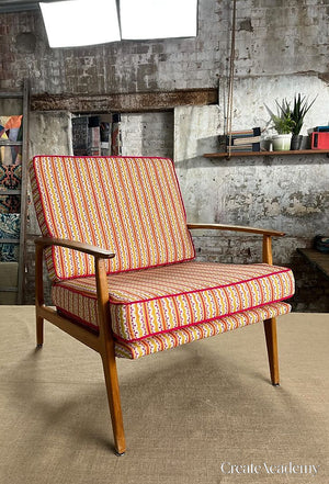 Heatwave linen by Bethie Tricks in orange and pink, wavy block-print stripes upholstered on an armchair