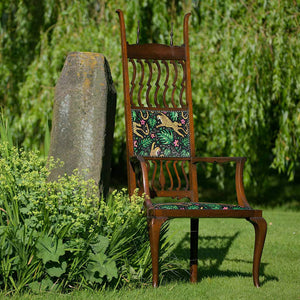 How the Leopard Got His Spots velvet by The Monkey Puzzle Tree in green and orange on an upholstered chair