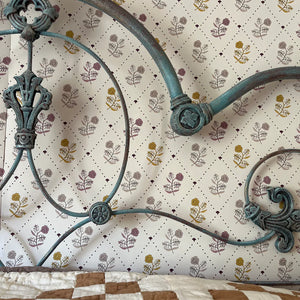 Jaipur wallpaper by Parker and Jules in cream and yellow, block-print flowers on a trellis in a bedroom