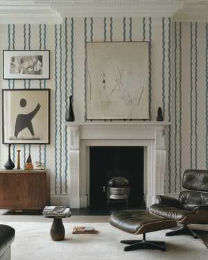 Jester Lines wallpaper by Annika Reed in blue, wavy jester lines around a fireplace