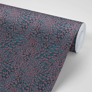 Leopard wallpaper by Tatie Lou in burgundy, partly unrolled roll showing a leopard-spot print