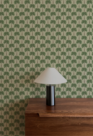 Little Palma wallpaper by Deus ex Gardenia in beige and green, rows of palm trees above a sideboard